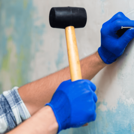 roofing hammer driving nail into shingles